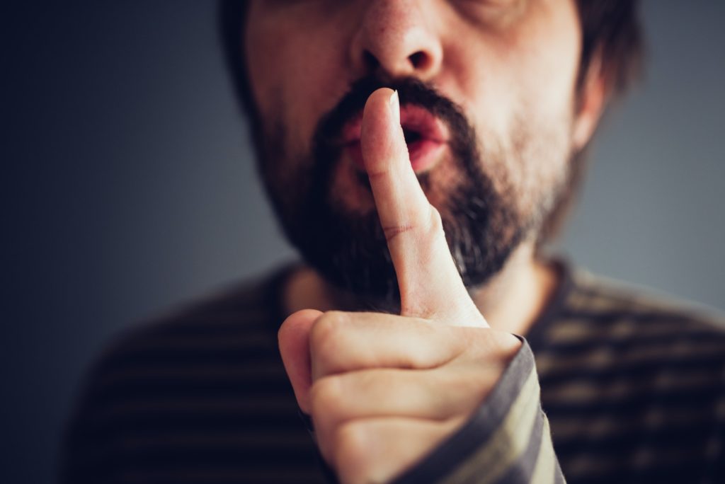 Man saying hush or be quiet
